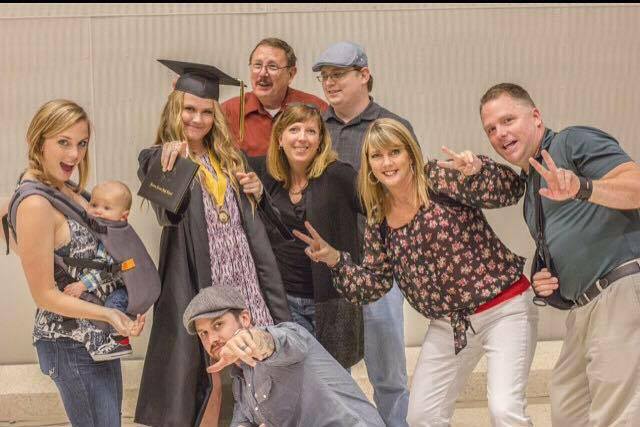 Kelsey graduating high school taking a picture with her family