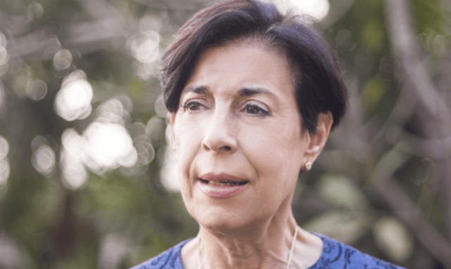 Foto de cerca Antonieta cerca de unos arboles.