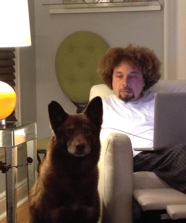 Malcolm with his dog as he works on his laptop.