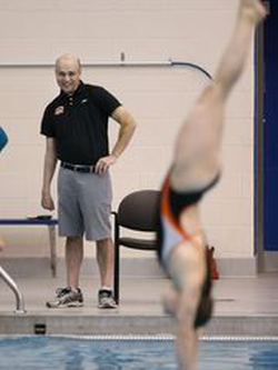 Cliff Devries standing poolside as an RIT student dives