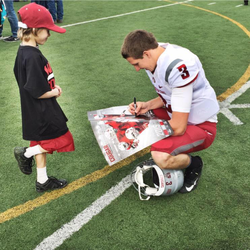 Tyler Hilinski autographing a poster for a young fan