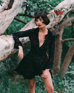 Photo of Taylor Lashae wears a black dress out in a garden.