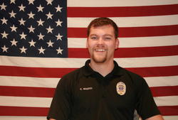 Officer Maddox next to the American flag