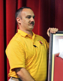 Photo of Christopher Hixon being presented an award for his excellence.