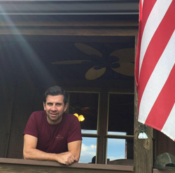 Martin McLean stands next to an American Flag (disambiguation).