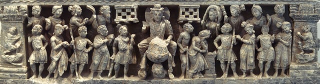 The "Great Departure" of Siddhartha Gautama, surrounded by a halo, he is accompanied by numerous guards, maithuna loving couples, and devata who have come to pay homage; Gandhara, Kushan period