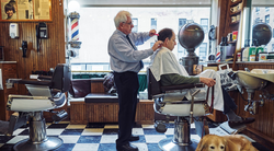 Photo of Adrian Wood cutting a man's hair.
