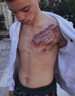 Lil Mosey showing off his "Thank God" tattoo on his chest