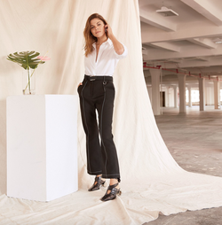 Photo of Emily Weiss modeling for Vogue as she wears a Tod’s shirt, Louis Vuitton pants, and J.W.Anderson shoes in Glossier’s new Manhattan headquarters.