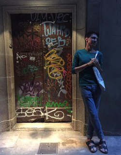 Rex Santus standing near graffiti art.