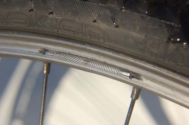 Aluminium rim worn-out by V-brakes. The outer wall has been worn through and the wheel is dangerously weakened. This is a disadvantage of rim brakes.