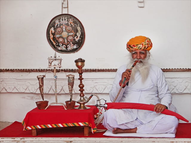 An Indian man smoking Tobacco on hookah, Rajasthan, India.