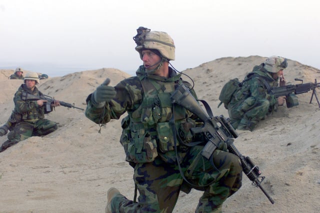 A squad leader with the 15th Marine Expeditionary Unit (Special Operations Capable) (15th MEU (SOC)), moves his Marines to their objective during a mission in support of Operation Iraqi Freedom