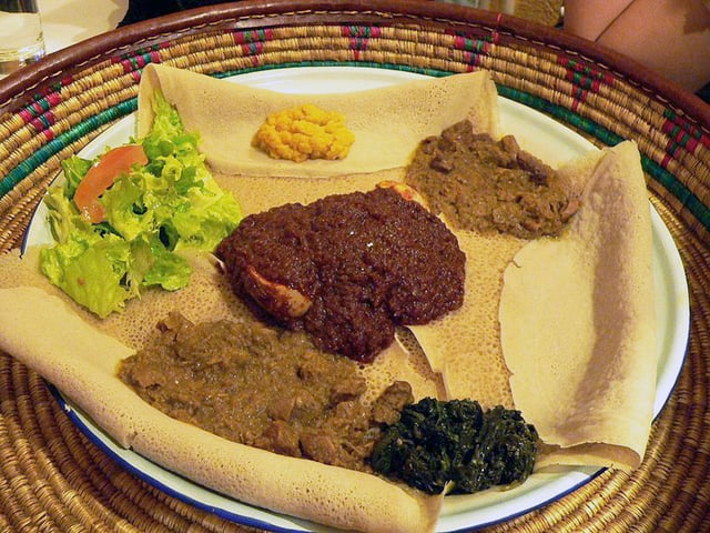 Typical Ethiopian cuisine: Injera (pancake-like bread) and several kinds of wat (stew)