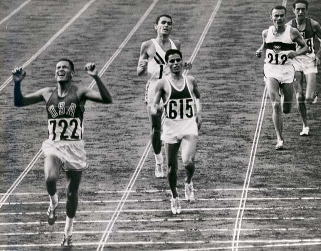 Billy Mills crosses the finish line at the end of the 10,000-meter race at the 1964 Tokyo Olympics.