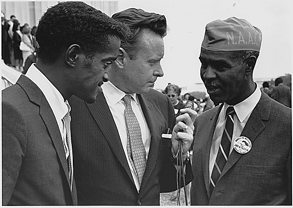 Wilkins (right) with Sammy Davis, Jr. (left) and a reporter at the 1963 Civil Rights March on Washington, D.C.