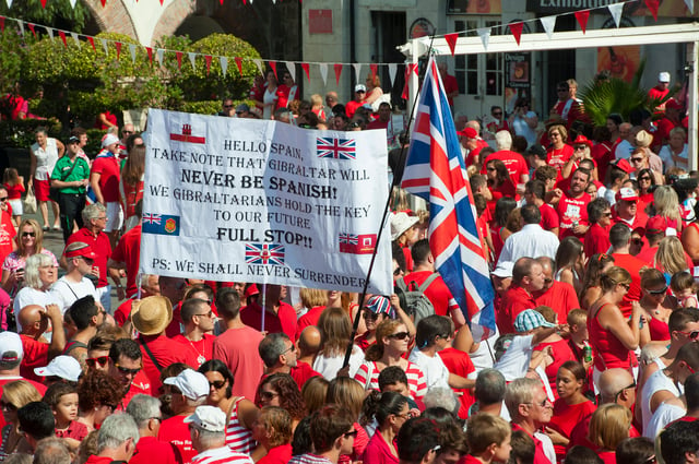 Thousands of Gibraltarians dress in their national colours of red and white during the 2013 Gibraltar National Day celebrations. Gibraltarians were the only group of overseas territories residents who could apply for full British citizenship without restrictions before 2002.