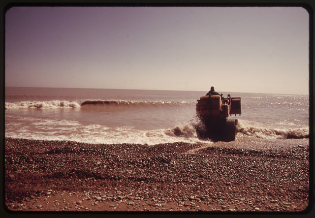 A bulldozer piles boulders in an attempt to prevent lake shore erosion, 1973 (photograph by Paul Sequeira, photojournalist and contributing photographer to the Environmental Protection Agency's DOCUMERICA project in the early 1970s)