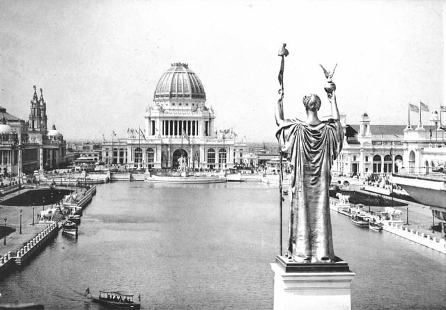 Daniel Chester French's original statue The Republic at the World's Columbian Exposition of 1893 in Chicago, facing the Administration Building across the Great Basin. This version had a Phrygian cap draped on the staff.
