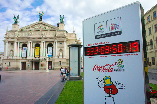 Clock in Lviv on Prospekt Svobody (Freedom Ave.), showing time to start of EURO 2012. Opera and Ballet Theatre in background