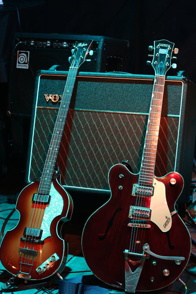 A Höfner "violin" bass guitar and Gretsch Country Gentleman guitar, models played by McCartney and Harrison, respectively; the Vox AC30 amplifier behind them is the model the Beatles used during performances in the early 1960s.