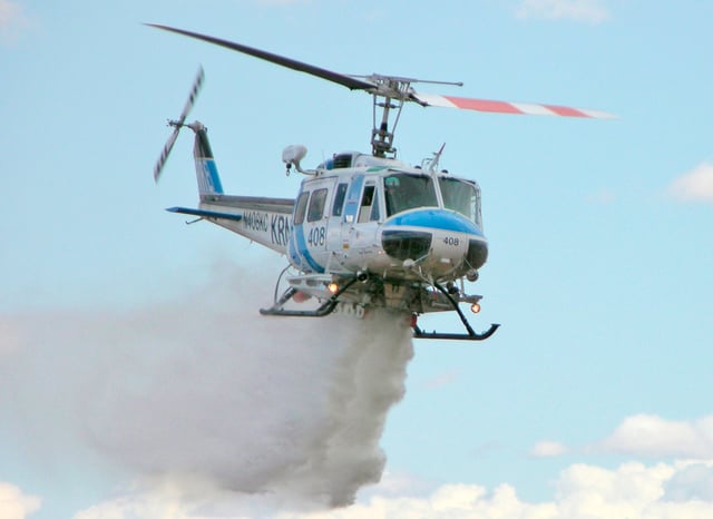 A Bell 205 dropping water onto a fire