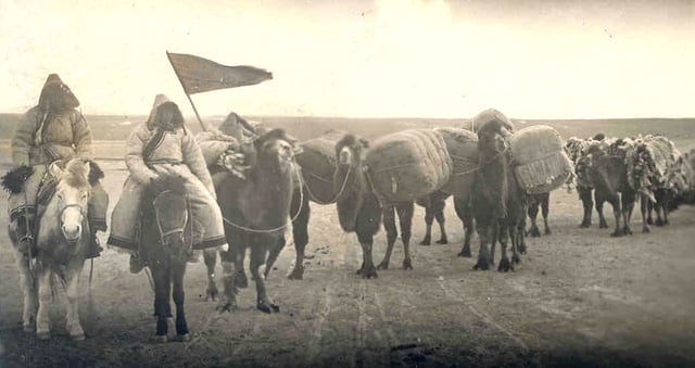 An image of an early 20th-century Oirat caravan, traveling on horseback, possibly to trade goods.