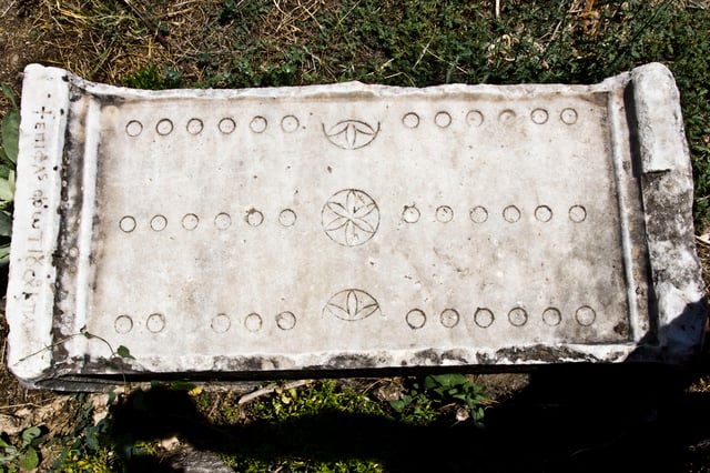 Stone game board from Aphrodisias: boards could also be made of wood, with deluxe versions in costly materials such as ivory; game pieces or counters were bone, glass, or polished stone, and might be coloured or have markings or images