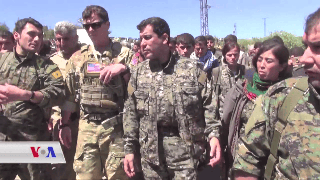 A US military officer and YPG and YPJ commanders tour an area hit by Turkish airstrikes in April 2017