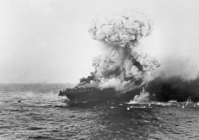 The aircraft carrier USS Lexington explodes on 8 May 1942, several hours after being damaged by a Japanese carrier air attack.