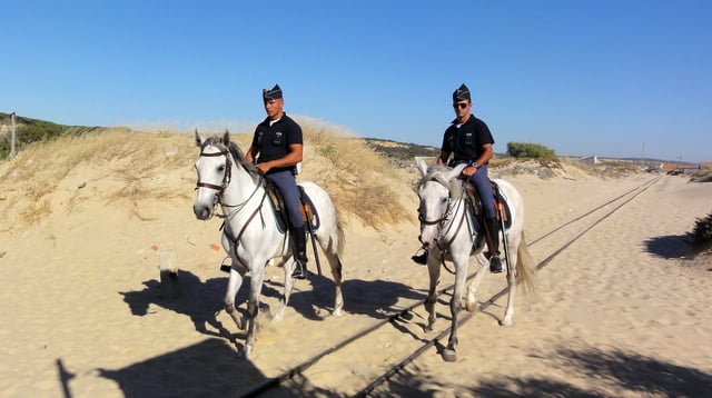 GNR cavalry patrol with horses, at Praia da Saúde (in English, Beach of Health) Costa da Caparica, next to Almada, and 15 kilometers of the Lisbon city in Portugal.