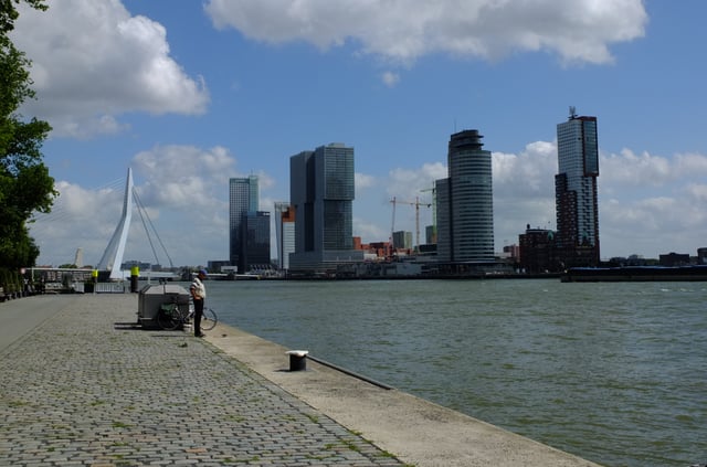 The Wilhelmina pier at the Kop van Zuid in the distance. A part of Rotterdam with many skyscrapers and high-rises. On the left the Erasmus Bridge can be seen.