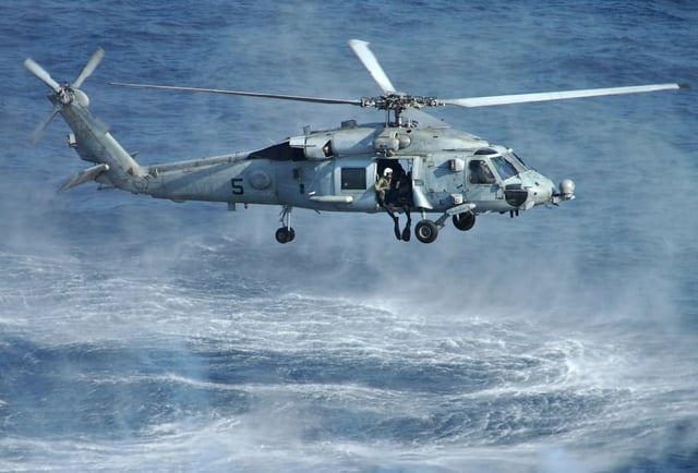 An HH-60H Seahawk deploying a SAR swimmer