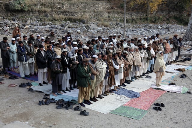 Men doing Islamic salat (praying) outside in the open in the Kunar Province of Afghanistan
