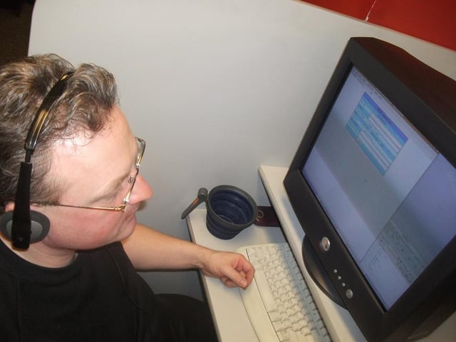 A call centre worker confined to a small workstation/booth.