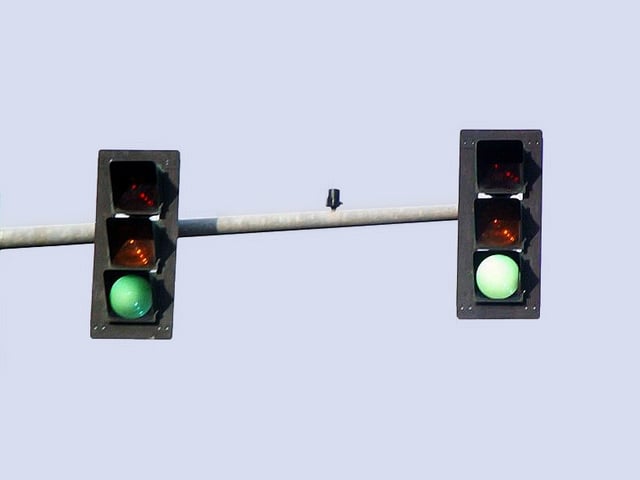 The same two signals above, taken in the signal's intended viewing area (a single lane of northbound traffic). Special light-diffusing optics and a colored fresnel lens create the indication.