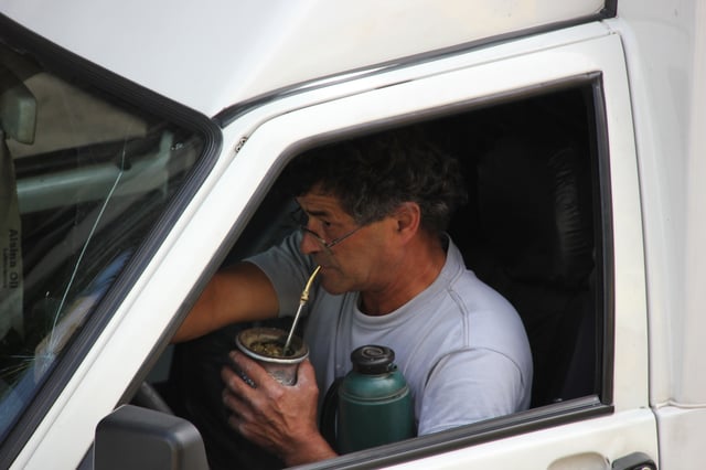 A man drinking mate in his car