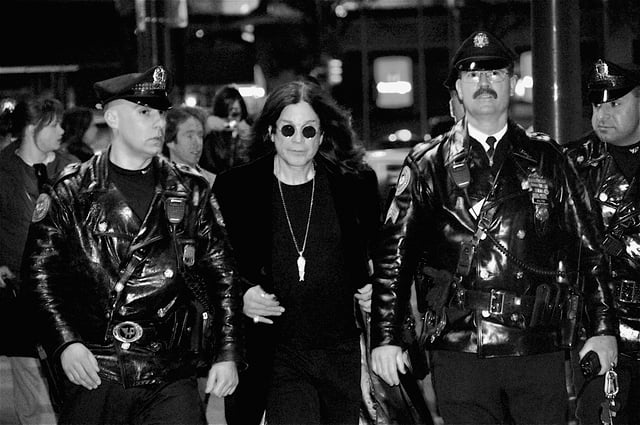 Osbourne, flanked by Philadelphia police officers, leaves Borders in Center City after signing copies of his autobiography, I Am Ozzy on 27 January 2010.