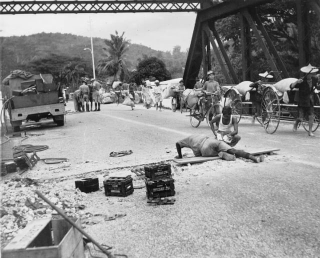 Combat Engineers prepare a bridge for demolition in Malaya.