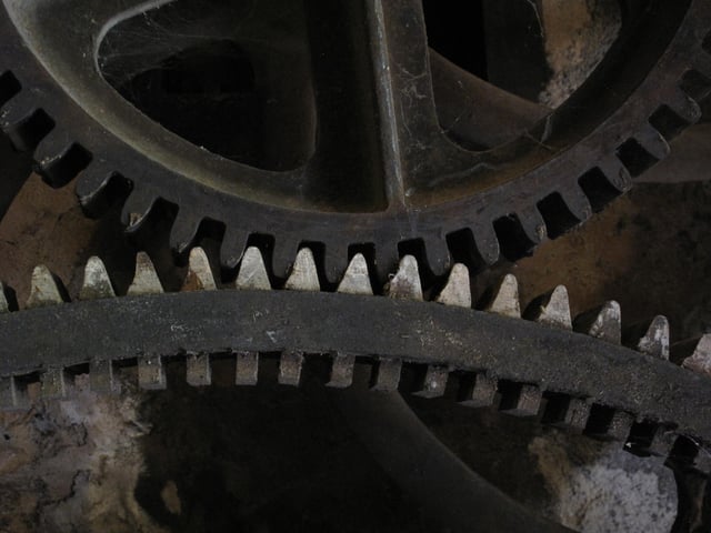 A cast gearwheel (above) meshing with a cogged mortise wheel (below).