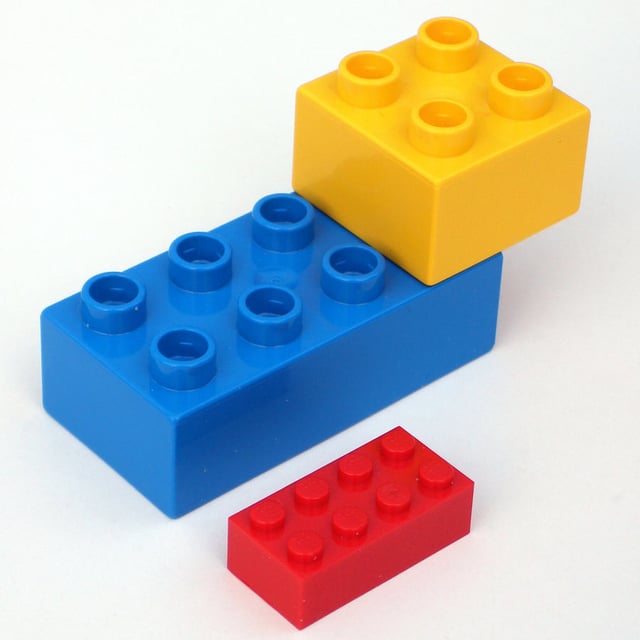 Two Lego Duplo bricks with a standard brick for comparison