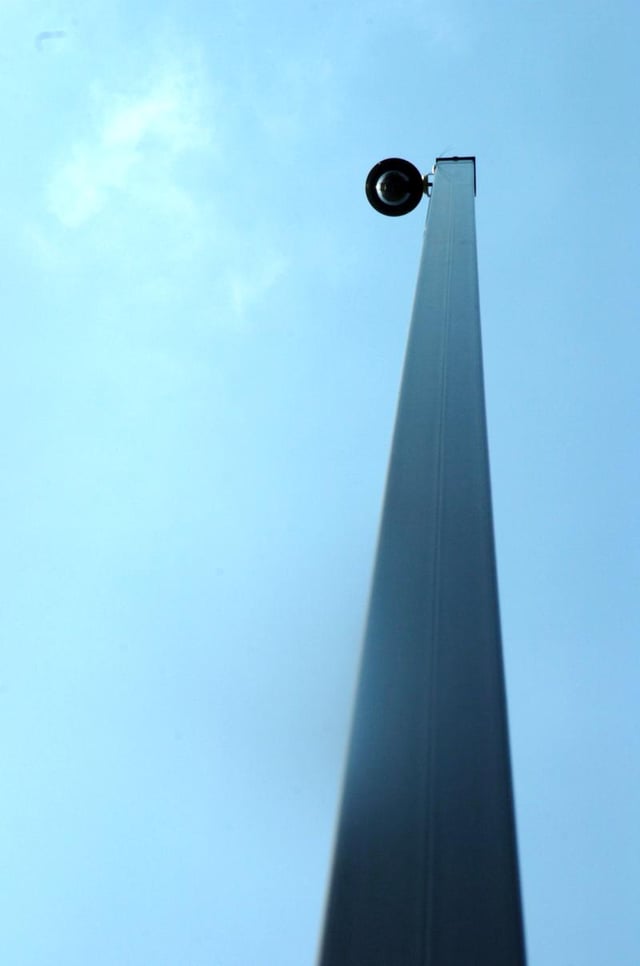 Eye-in-the-sky surveillance dome camera watching from a high steel pole