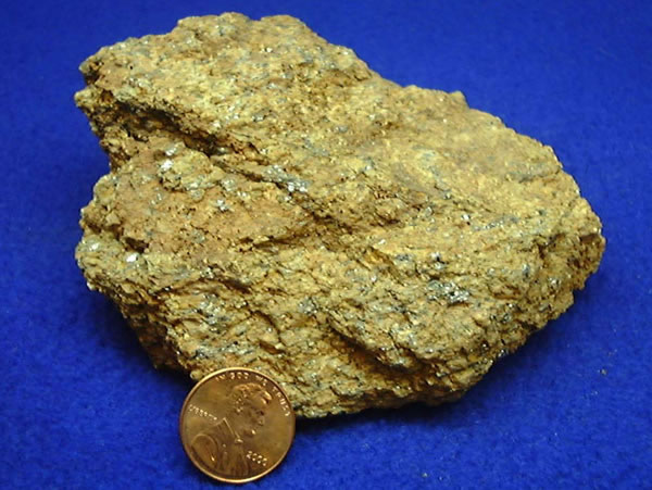 Graphite ore, shown with a penny for scale