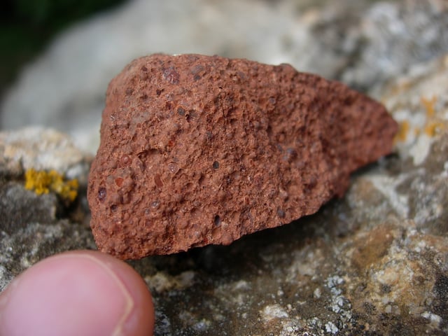 Bauxite, a major aluminium ore. The red-brown color is due to the presence of iron oxide minerals.