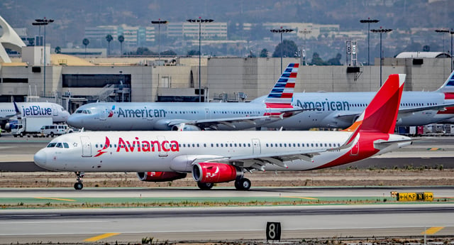 An Avianca Airbus A321 with numerous American Airlines aircraft in the background