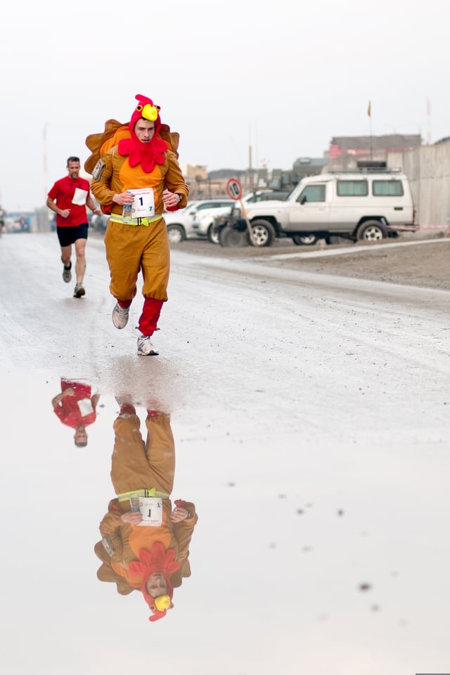 U.S. Army serviceman dressed in a turkey costume leads the Kabul Satellite Turkey Chase 10K Run on Thanksgiving Day, 2011