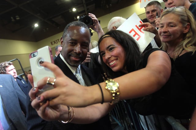 Carson taking a photo with a supporter at a rally in August 2015