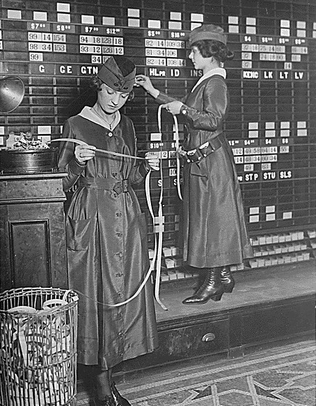Women operating stock market board and a ticker tape machine at the Waldorf in 1918, during World War I.