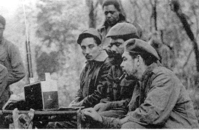 Listening to a Zenith Trans-Oceanic shortwave radio receiver are (seated from the left) Rogelio Oliva, José María Martínez Tamayo (known as "Mbili" in the Congo and "Ricardo" in Bolivia), and Guevara. Standing behind them is Roberto Sánchez ("Lawton" in Cuba and "Changa" in the Congo), 1965.