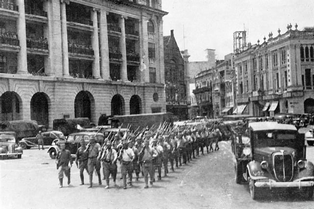 Battle of Singapore, February 1942. Victorious Japanese troops march through the city center. (Photo from Imperial War Museum)